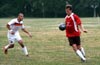 Gary Easlick of Tortorella chest trapping the ball in front of Julian Munoz of Bateman